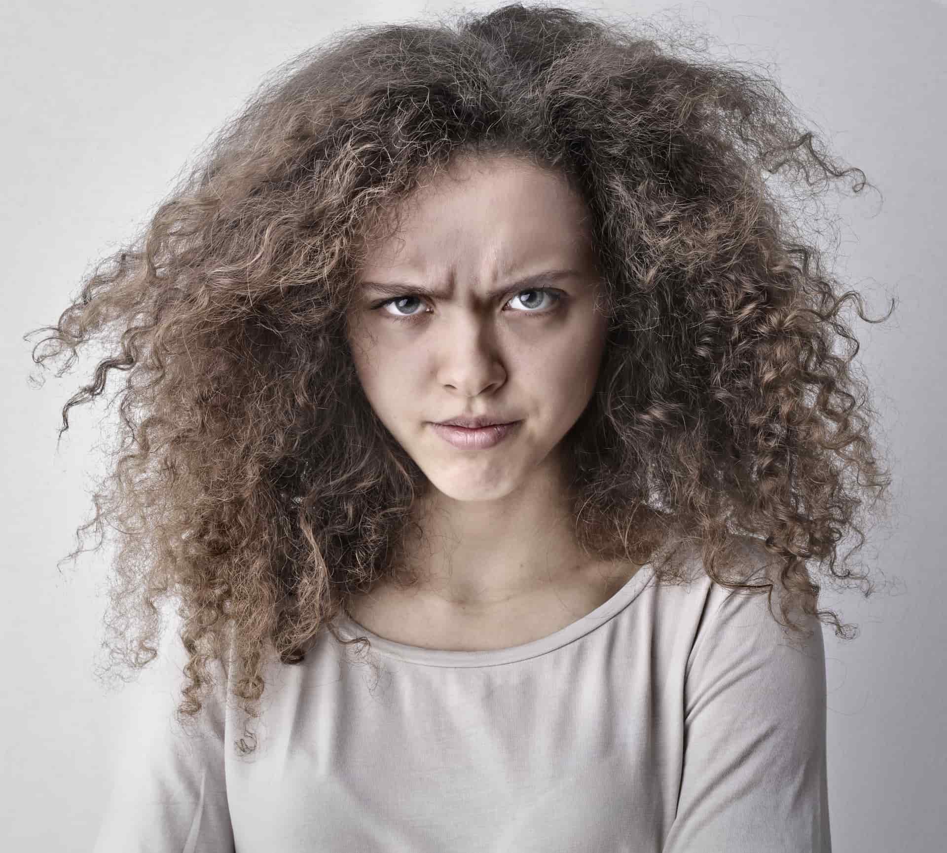 Frizzy hair backlit against a plain background