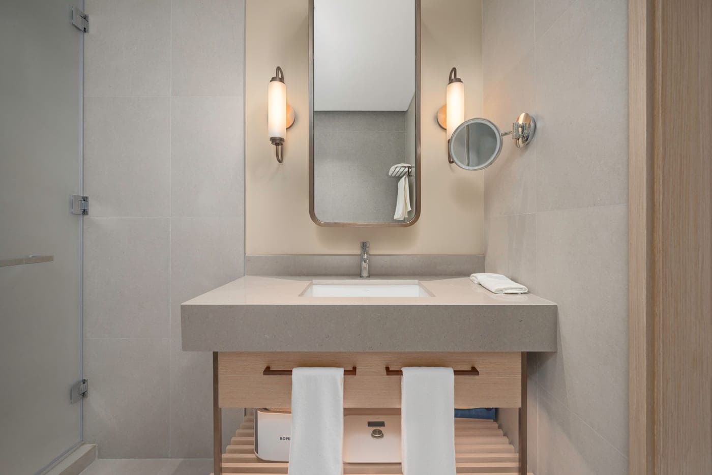 A hotel bathroom vanity and mirror