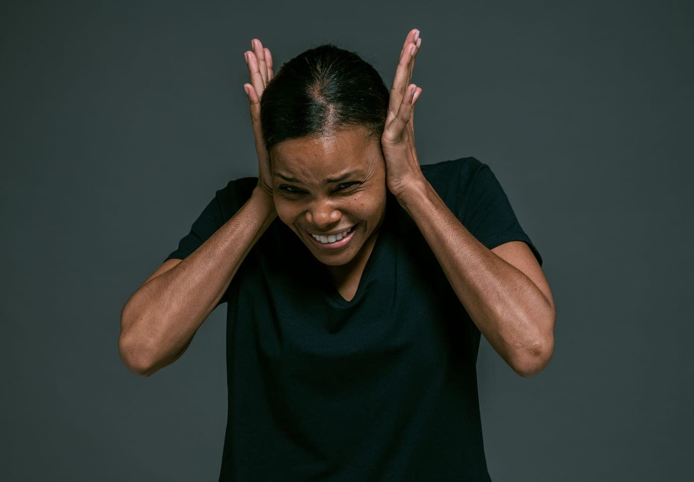 A person covering their ears against a loud sound