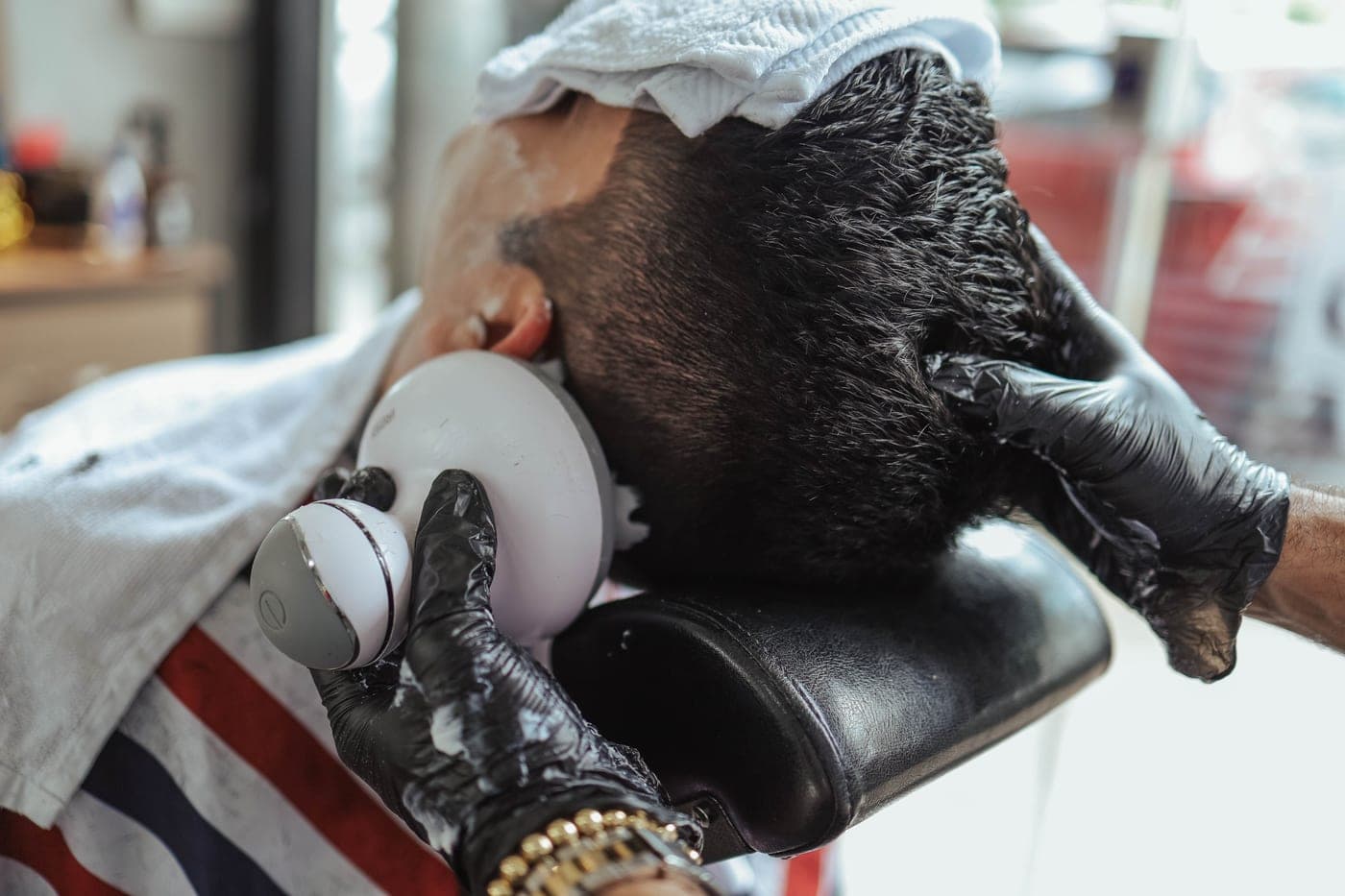 A scalp massage brush held in one hand