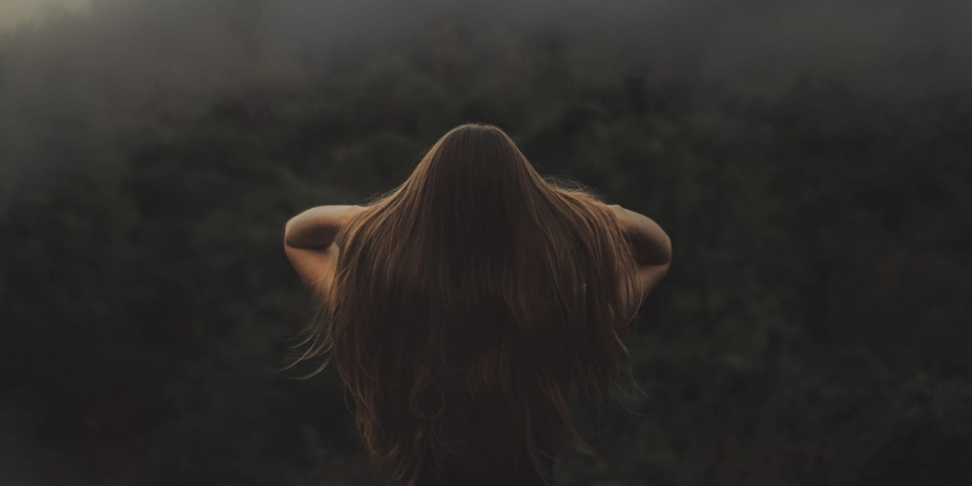 Long, dense hair falling over a shoulder